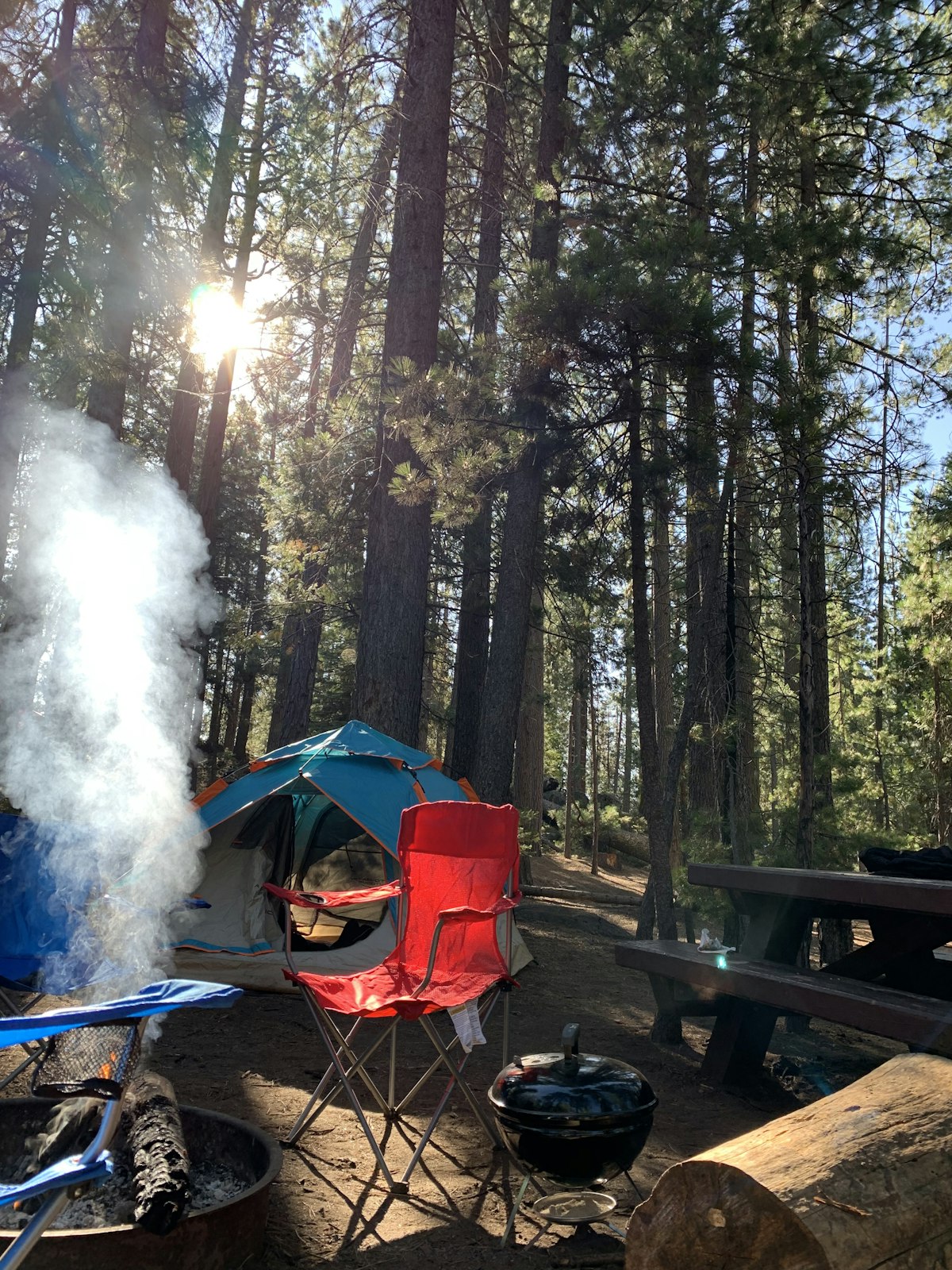 Hunter glassing for elk from a public land ridgeline with a backpack camp visible below