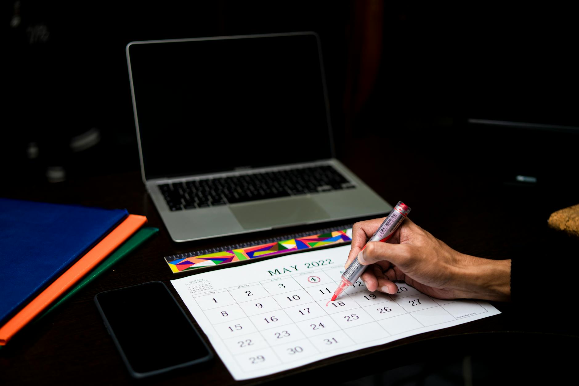 Western state hunting regulation booklets stacked with highlighted application deadline pages visible