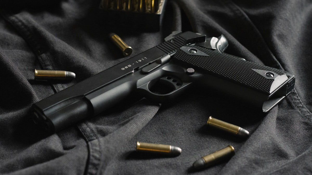 Rifle scope view of a mule deer at long range with bullet drop reference chart on a notebook