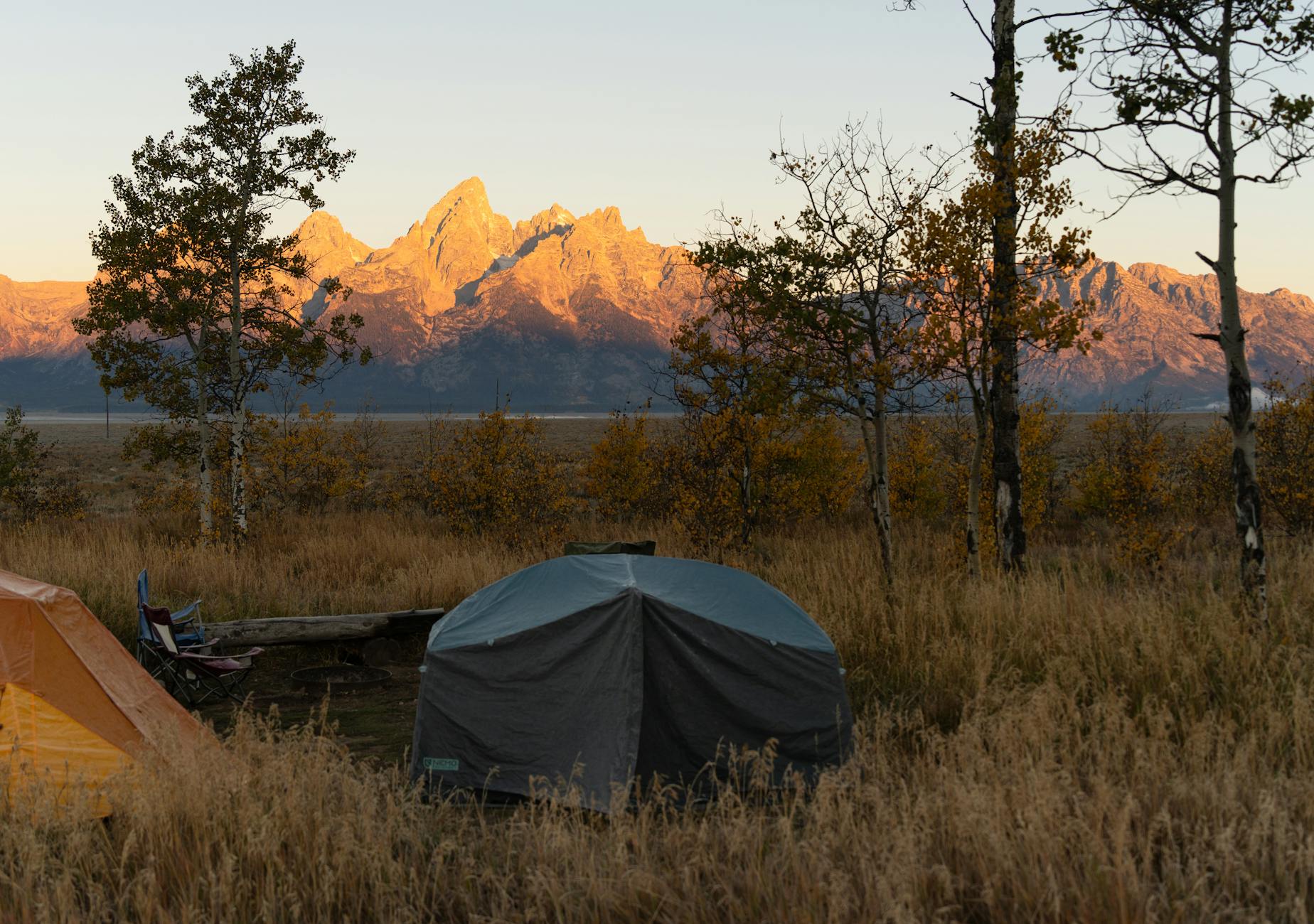 First-time western elk hunter glassing an alpine basin from a rocky overlook at dawn