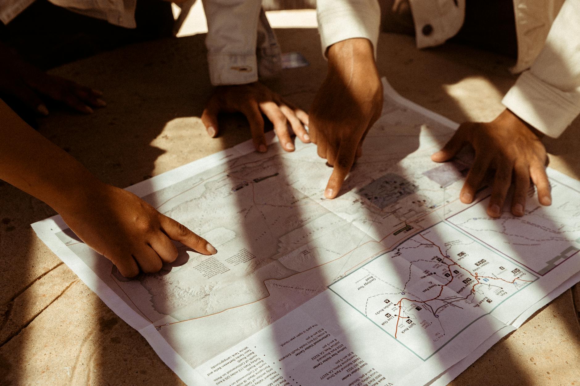 Four hunters gathered around a map at a base camp planning the next day's hunting strategy