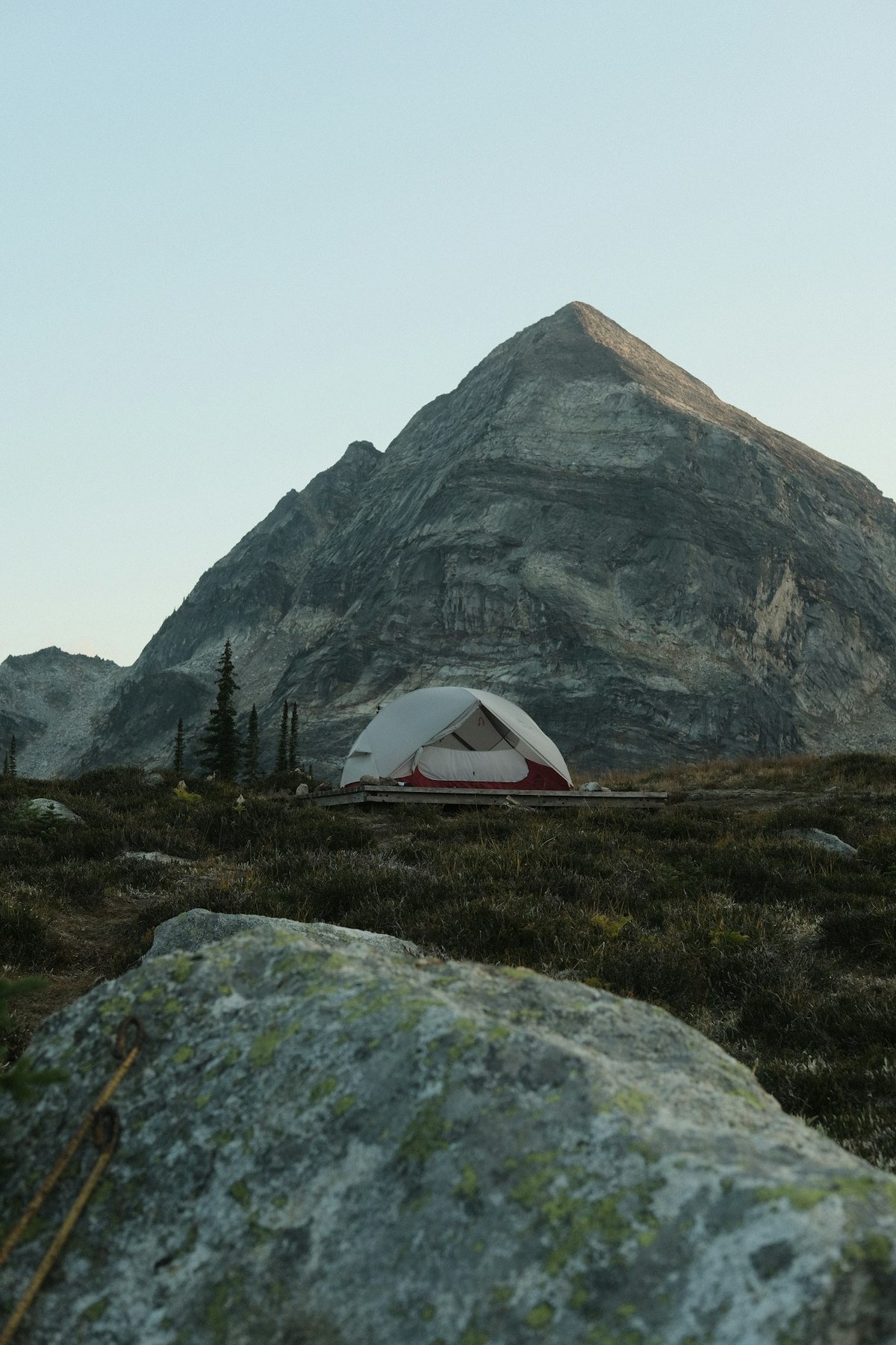Solo hunter with a loaded backpack hiking above treeline toward a high basin elk camp at sunrise